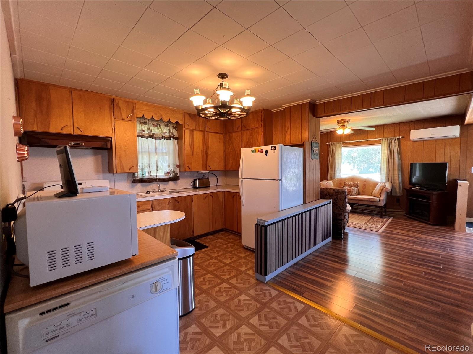 204 Main Street Genoa, CO 80818 - Photo 15 of 25 a kitchen with stainless steel appliances kitchen island granite countertop a refrigerator a stove a sink dishwasher and a dining table with garden view