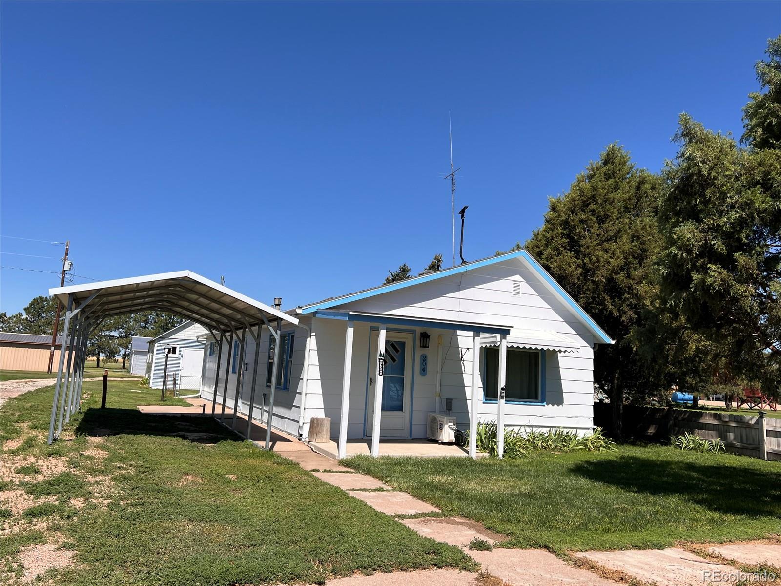 204 Main Street Genoa, CO 80818 - Photo 2 of 25 a front view of a house with a garden