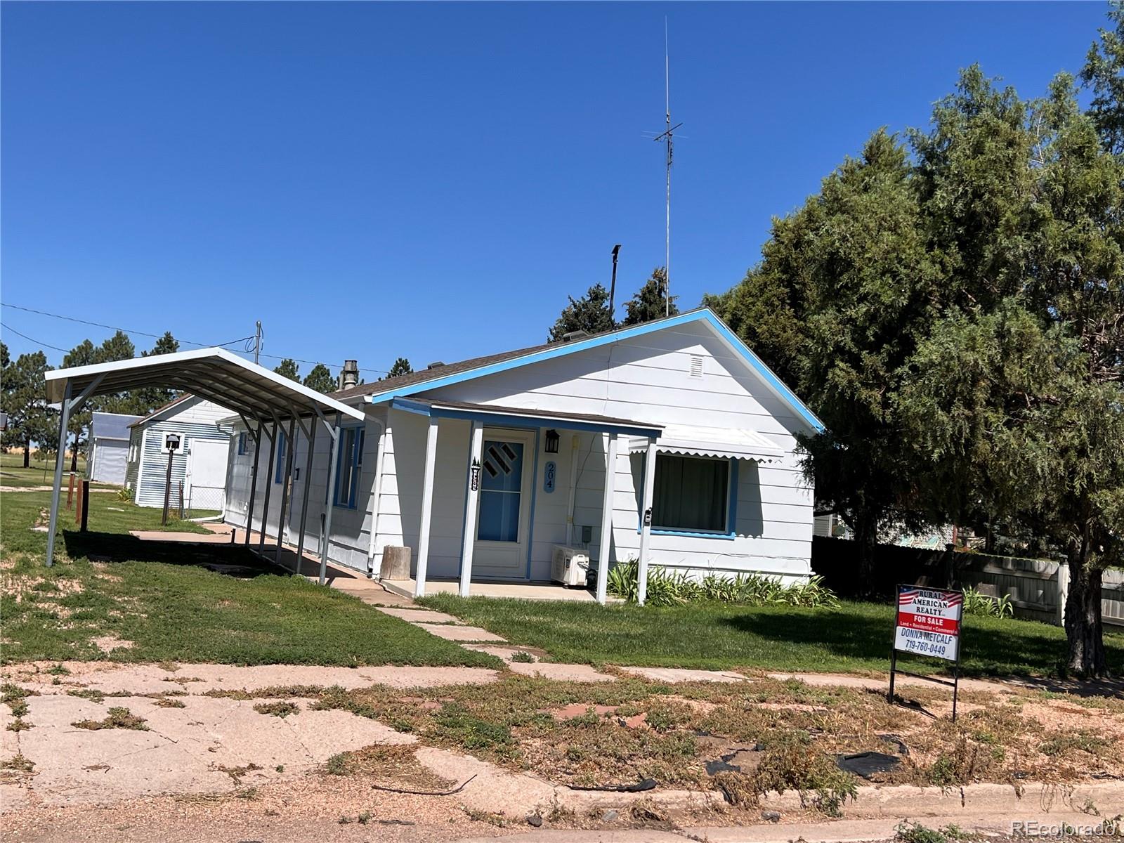 204 Main Street Genoa, CO 80818 - Photo 24 of 25 a front view of a house with a yard and garage