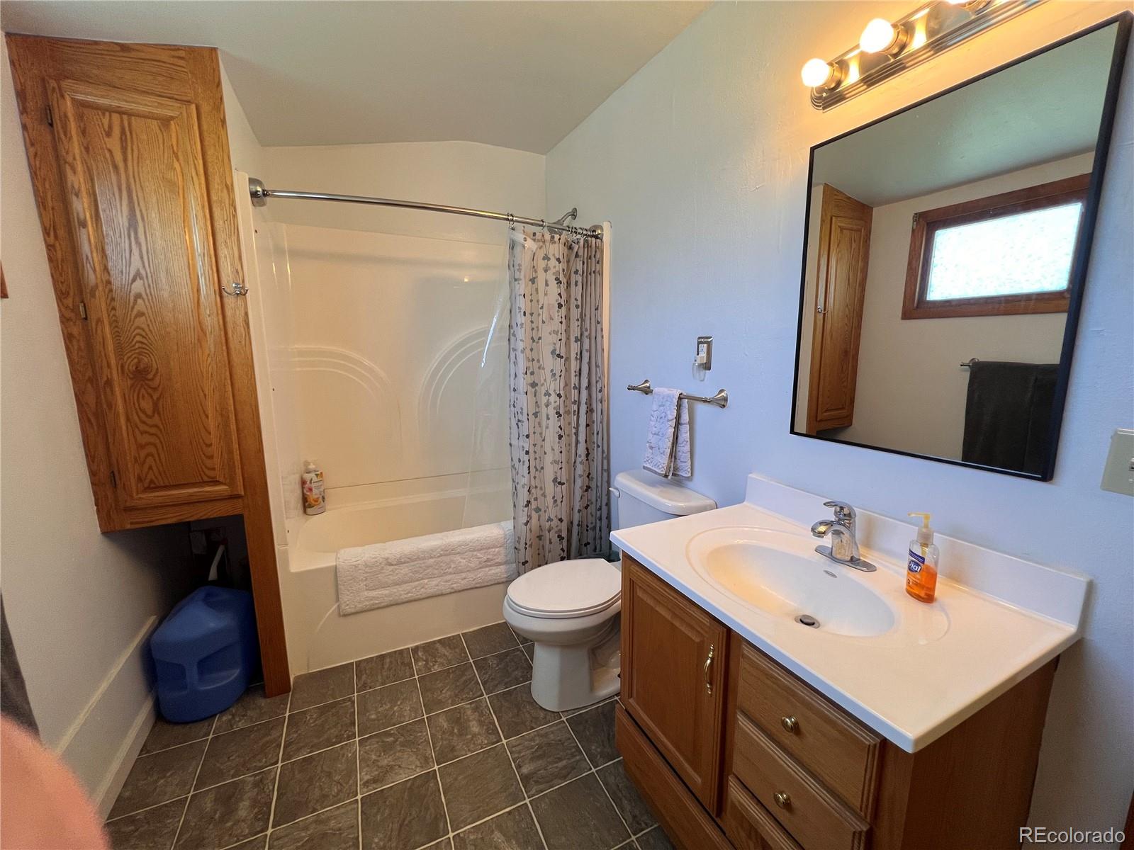 204 Main Street Genoa, CO 80818 - Photo 8 of 25 a bathroom with a sink a toilet a mirror and shower