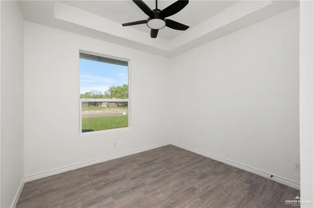 an empty room with a window and a ceiling fan