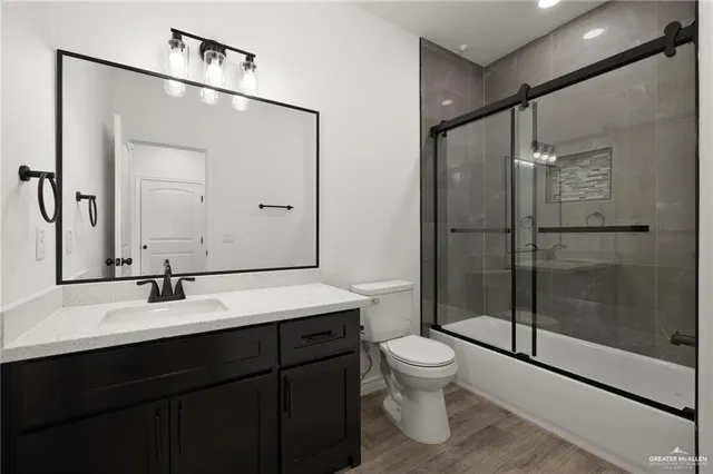 a bathroom with a shower sink mirror and toilet