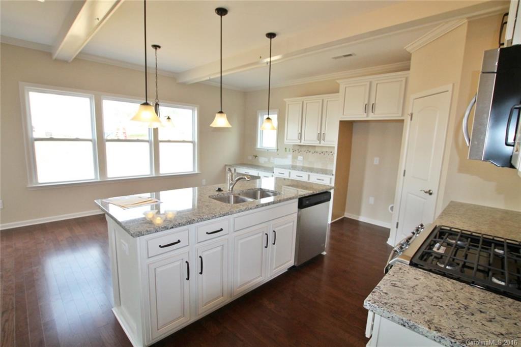 2032 Fuschia Court, Unit 136 Fort Mill, SC 29708 - Photo 8 of 22 a kitchen with stainless steel appliances granite countertop a stove a sink a refrigerator and white cabinets with wooden floor