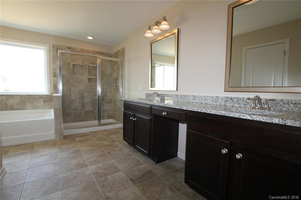 2032 Fuschia Court, Unit 136 Fort Mill, SC 29708 - Photo 10 of 22 a bathroom with a granite countertop sink a mirror and a bathtub
