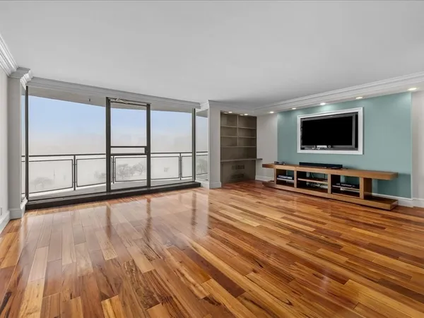 a view of a livingroom with wooden floor and furniture