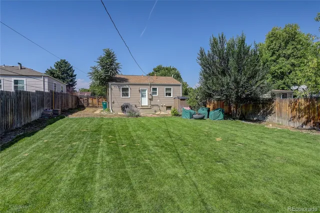 a view of a house with a big yard and a large trees