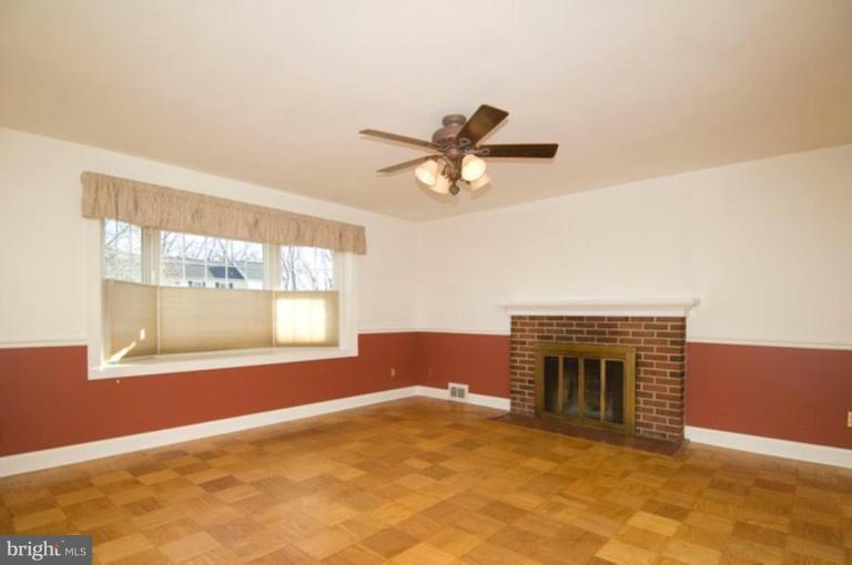 6804 Front Royal Road Springfield, VA 22151 - Photo 8 of 27 an empty room with a fireplace and windows