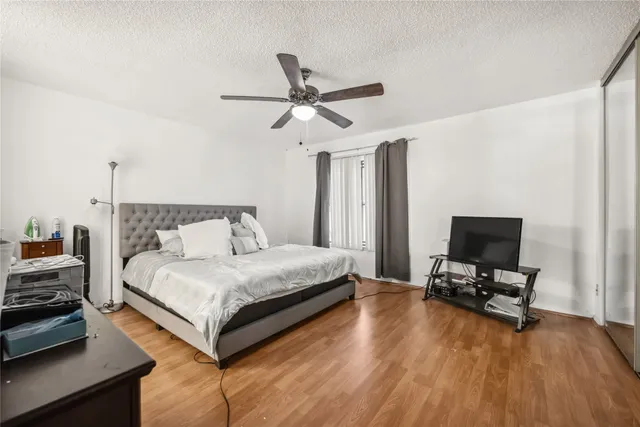a bedroom with a bed window and a flat screen tv