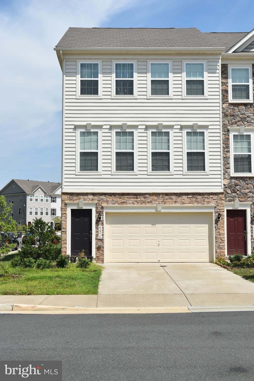 a front view of a house with a yard and a garage