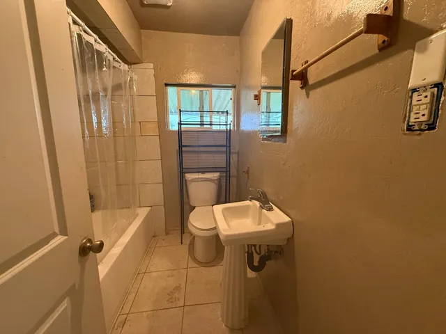 a bathroom with a toilet sink and shower