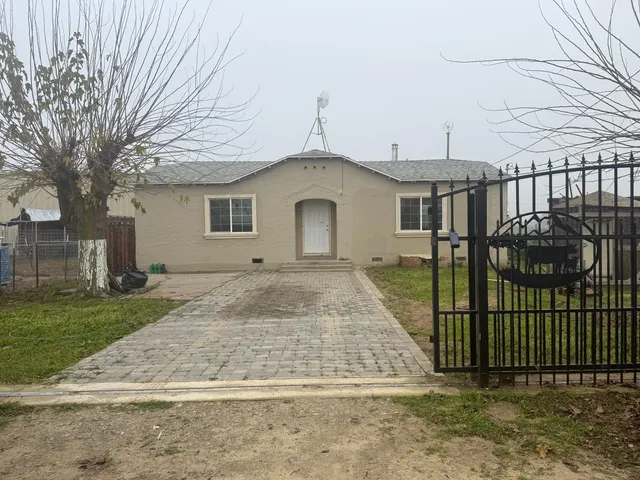 a view of a white house with a yard and plants