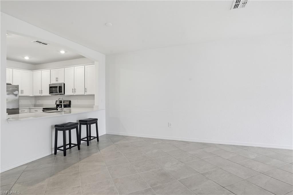 2215 Dragonfruit Way Naples, FL 34120 - Photo 13 of 38 a kitchen with cabinets and sink