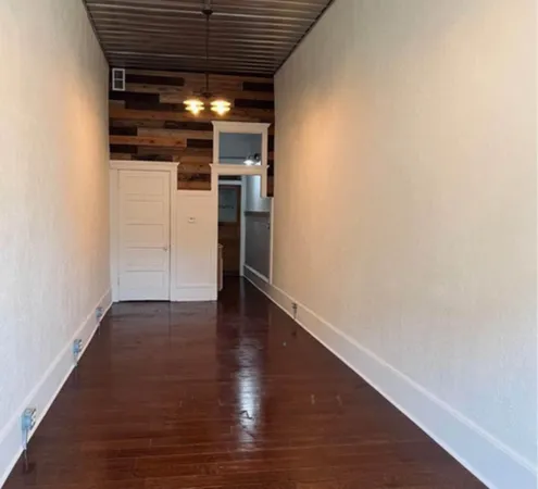 a view of empty room with wooden floor
