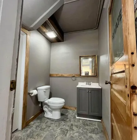 a bathroom with a toilet sink and mirror