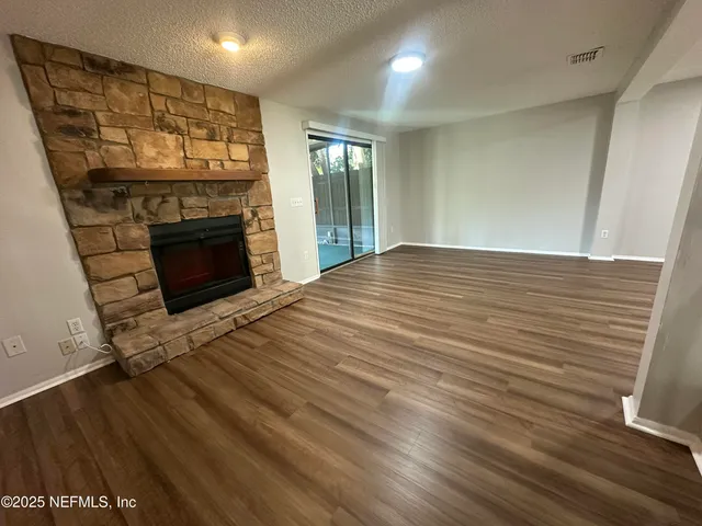 a view of empty room with wooden floor and fireplace