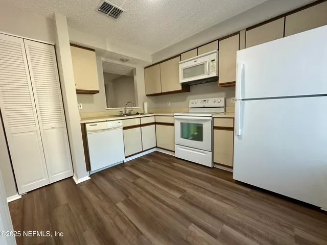 a kitchen with stainless steel appliances a refrigerator sink and microwave