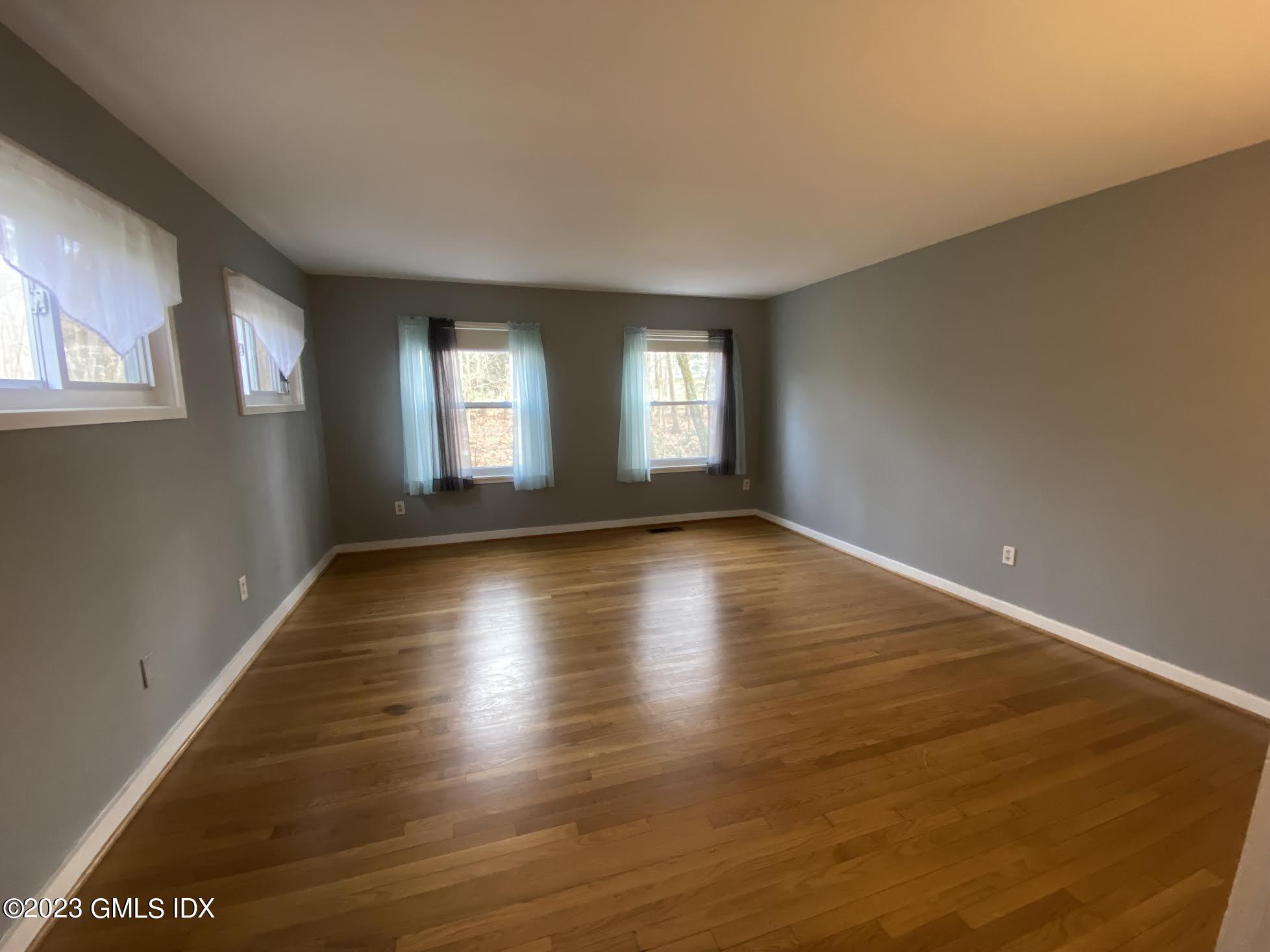 21 Hycliff Road Greenwich, CT 06831 - Photo 8 of 13 an empty room with wooden floor and windows