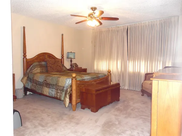 a spacious bedroom with a bed and a chandelier