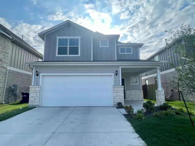 a front view of a house with a yard and a garage