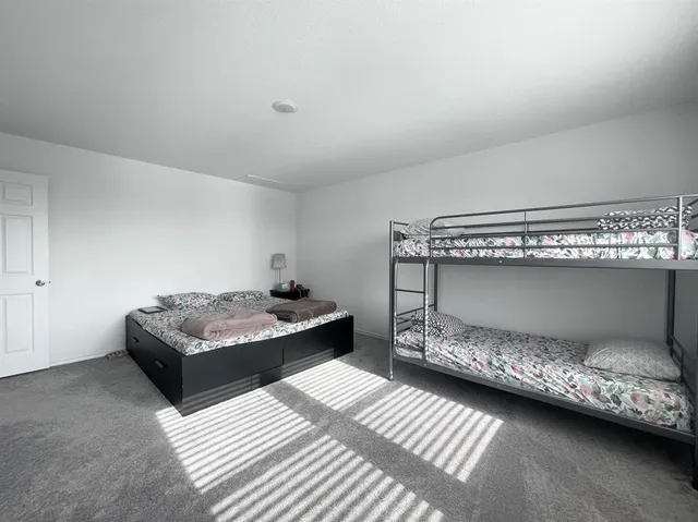 a view of a hallway with wooden floor and a bathroom