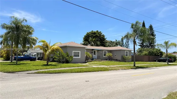 a front view of a house with a yard and trees