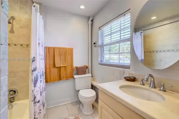 a bathroom with a granite countertop sink toilet a mirror and shower