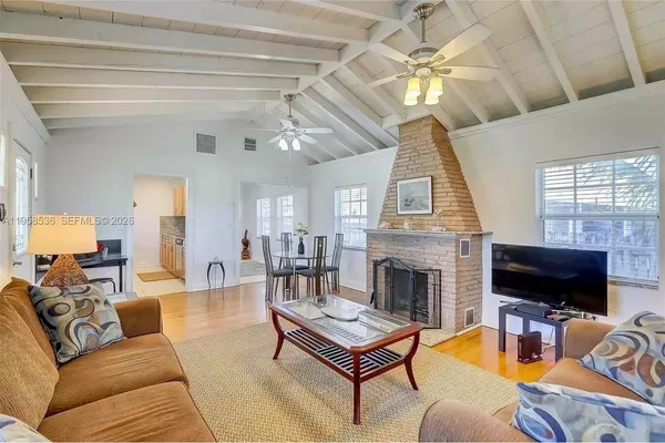 a living room with furniture a fireplace and a flat screen tv