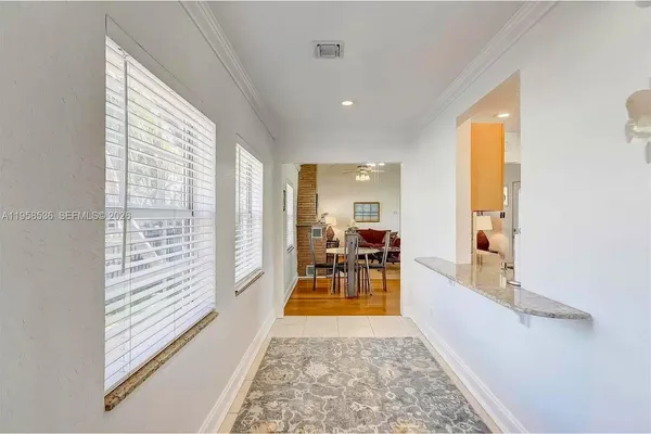 a view of a hallway with furniture and floor to ceiling window