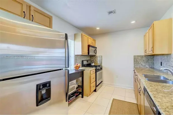 a kitchen with granite countertop stainless steel appliances and sink