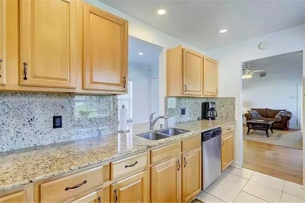 a kitchen with granite countertop a sink and cabinets