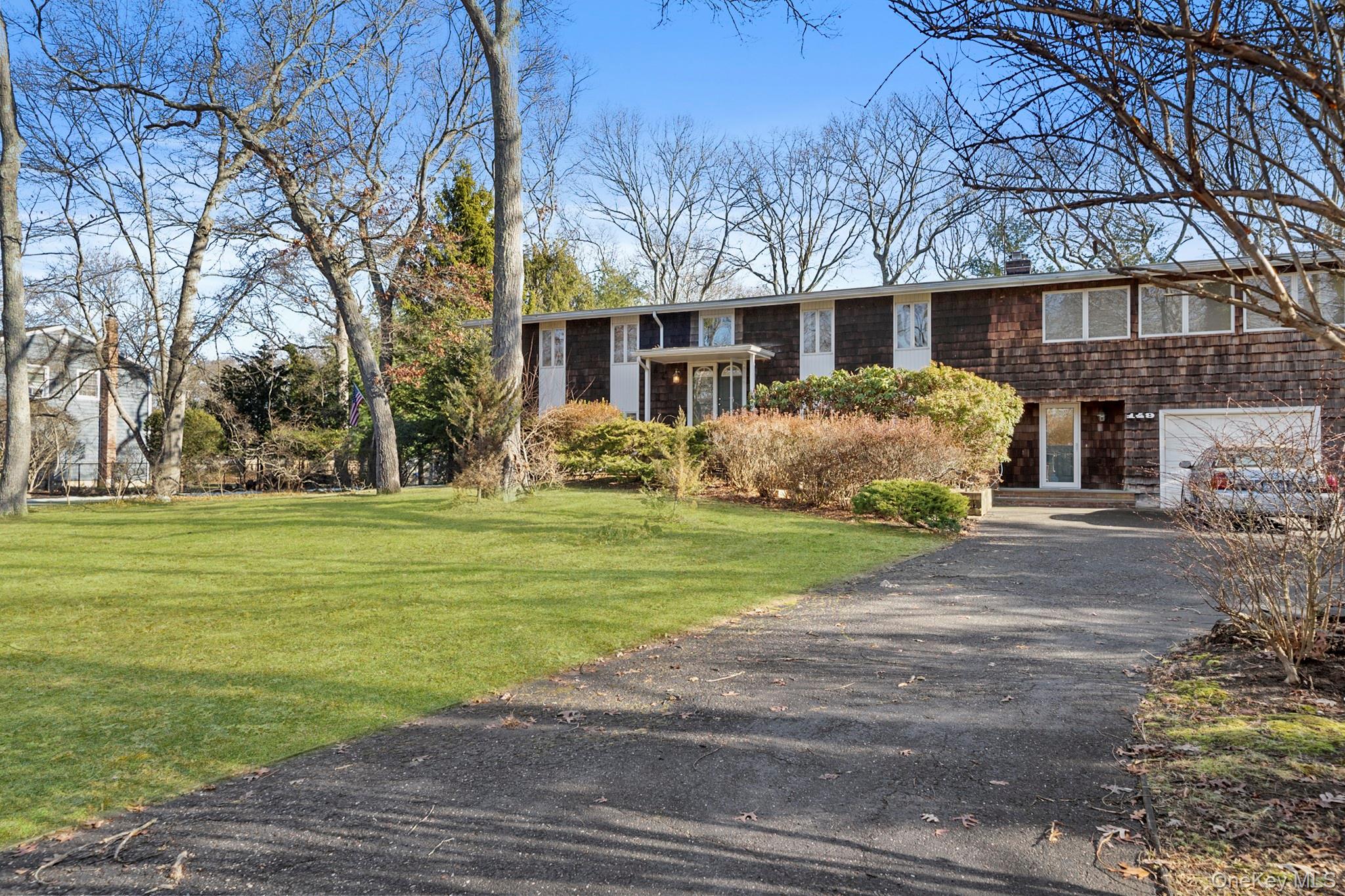 149 Munsell Road East Patchogue, NY 11772 - Photo 2 of 29 a front view of a house with garden