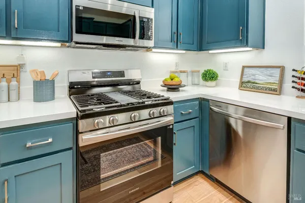 a kitchen with stainless steel appliances wooden cabinets and a stove top oven
