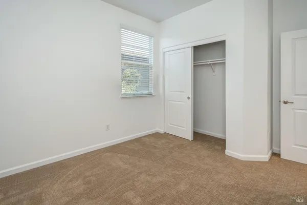 an empty room with windows and closet