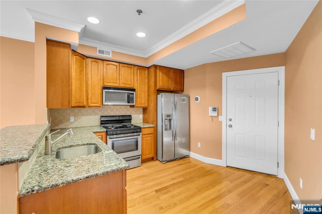 30 Austin Street, Unit 301 Newark, NJ 07114 - Photo 6 of 20 a kitchen with a sink stove and refrigerator