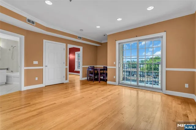 a view of empty room with wooden floor and furniture