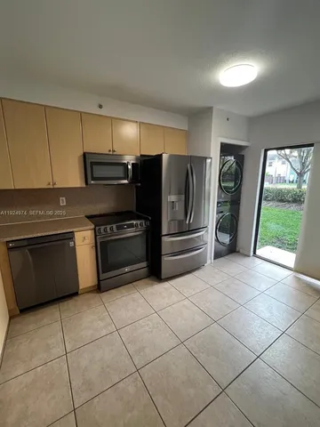 a kitchen with stainless steel appliances a stove a sink and a refrigerator