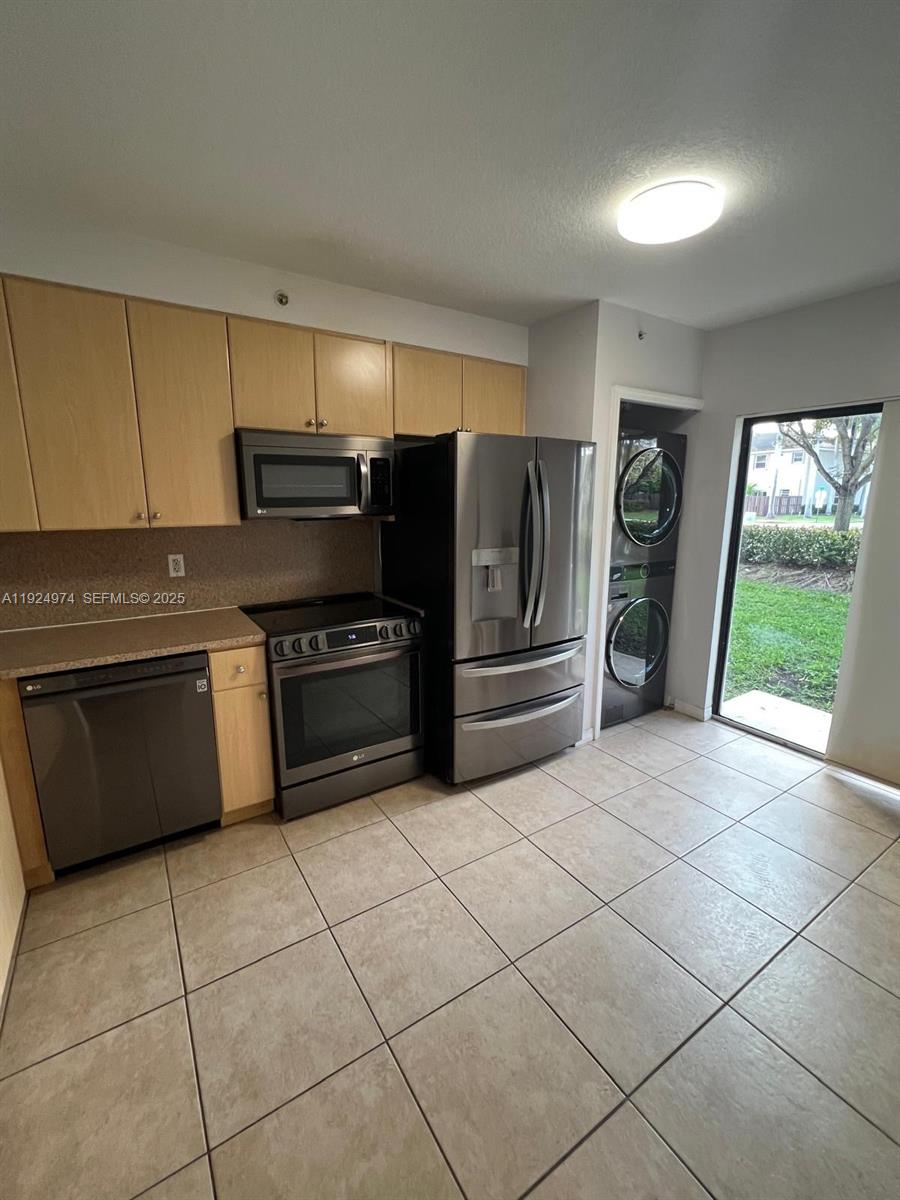22641 Southwest 88th Place, Unit 103 Cutler Bay, FL 33190 - Photo 2 of 12 a kitchen with stainless steel appliances a stove a sink and a refrigerator
