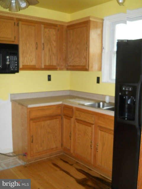 6707 Tweedbrook Road Baltimore, MD 21239 - Photo 7 of 19 a kitchen with a sink and cabinets