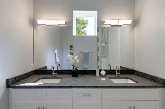 a bathroom with a granite countertop sink and a mirror
