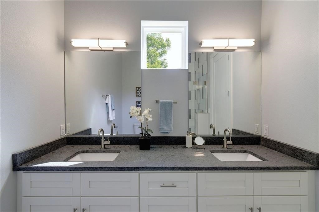 6405 Chesterfield Avenue, Unit A Austin, TX 78752 - Photo 12 of 15 a bathroom with a granite countertop sink and a mirror