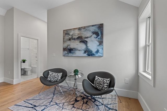 a view of a hallway to room with painting and a table