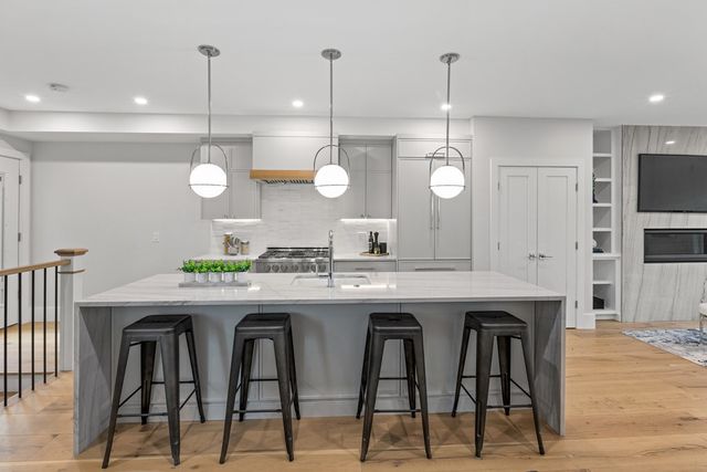 a kitchen with granite countertop a table chairs stove and cabinets