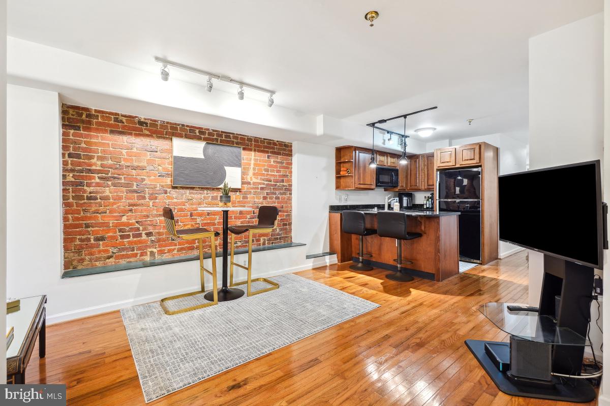 1514 21st Street Northwest, Unit 1 Washington, DC 20036 - Photo 5 of 29 a living room with furniture a flat screen tv and a floor to ceiling window
