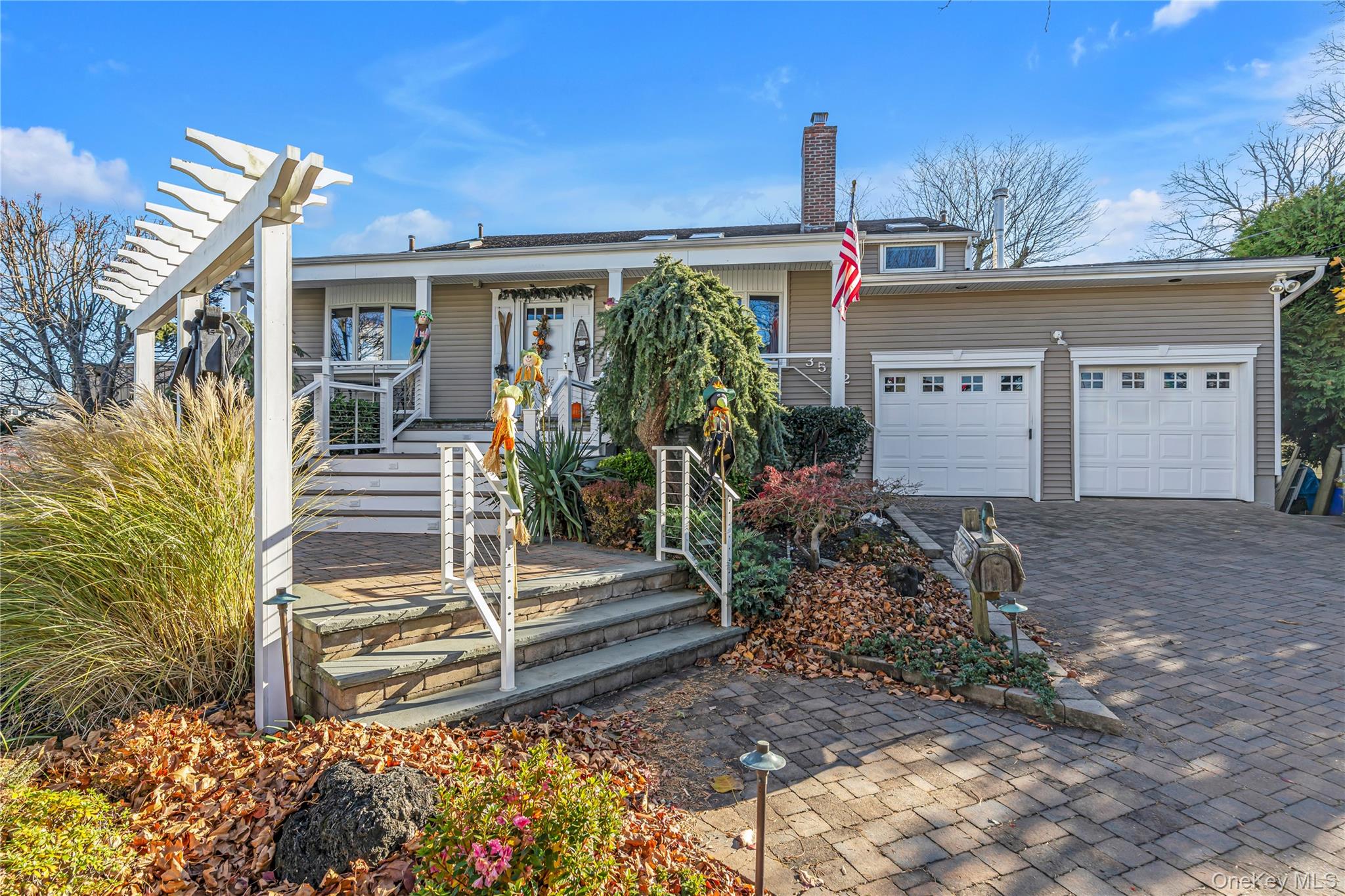 3522 Frederick Street Oceanside, NY 11572 - Photo 2 of 23 View of front of home featuring decorative driveway, a chimney, and a garage