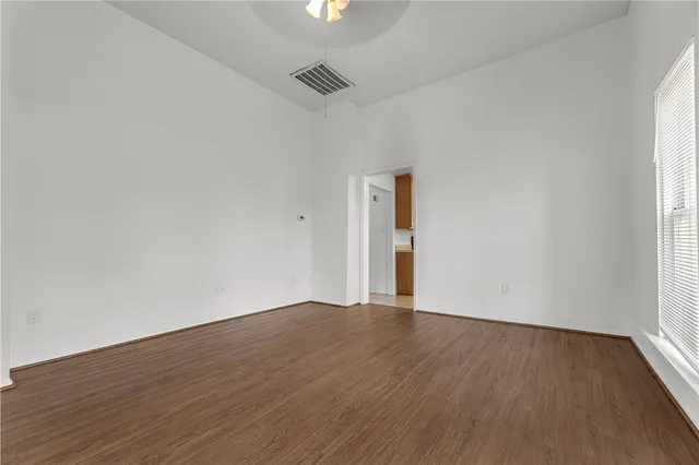a view of an empty room with wooden floor