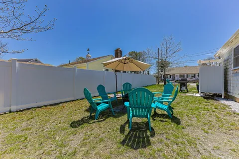 a view of a patio with table and chairs under an umbrella