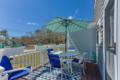 a view of a patio with a table and chairs under an umbrella
