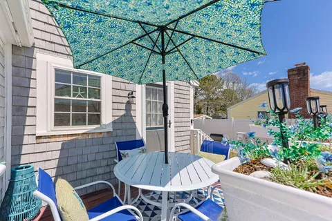 a view of a patio with a dining table and chairs under an umbrella