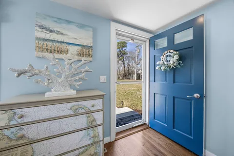 a view of a hallway with wooden floor and front door