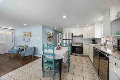 a kitchen with granite countertop cabinets and chairs